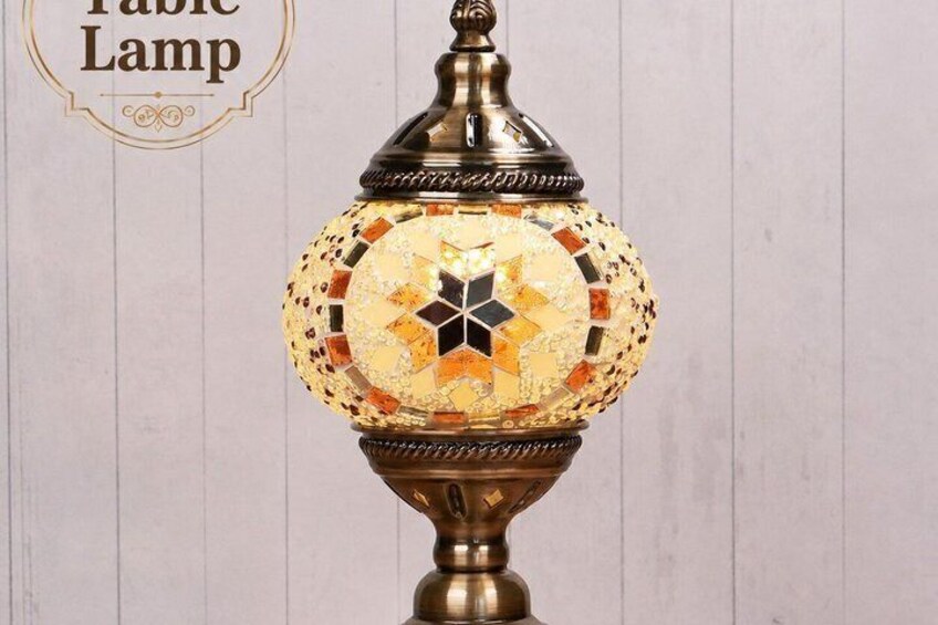 A decorative table lamp with a mosaic design and a brass base. 4