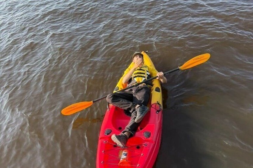 A person kayaking on a calm body of water. 2