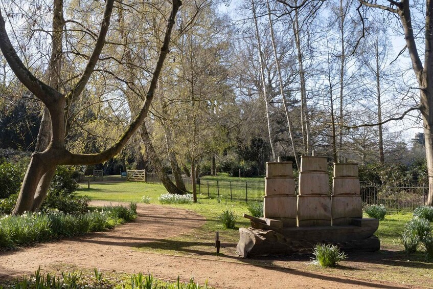 A park with a dirt path, trees, and a stone structure. 2