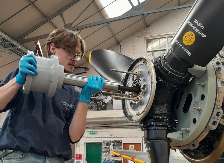 A person working on a mechanical part in a workshop. 4