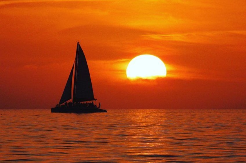 A sailboat on the water during sunset. 1