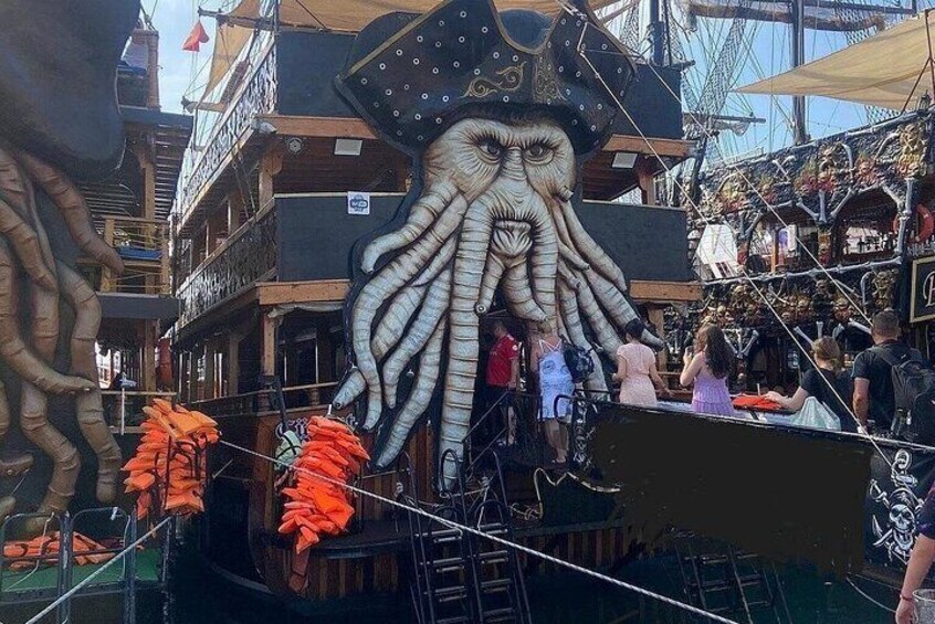 A ship with a large octopus figure and orange decorations. 1