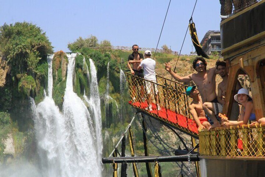A group of people on a wooden platform overlooking a waterfall. 5