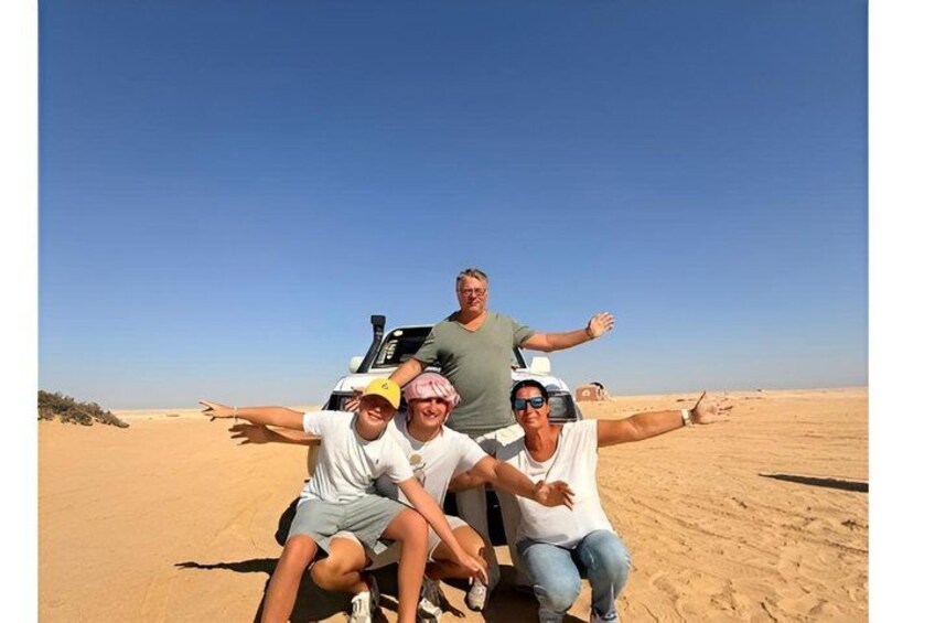 Four people in a desert landscape with a clear sky. 3
