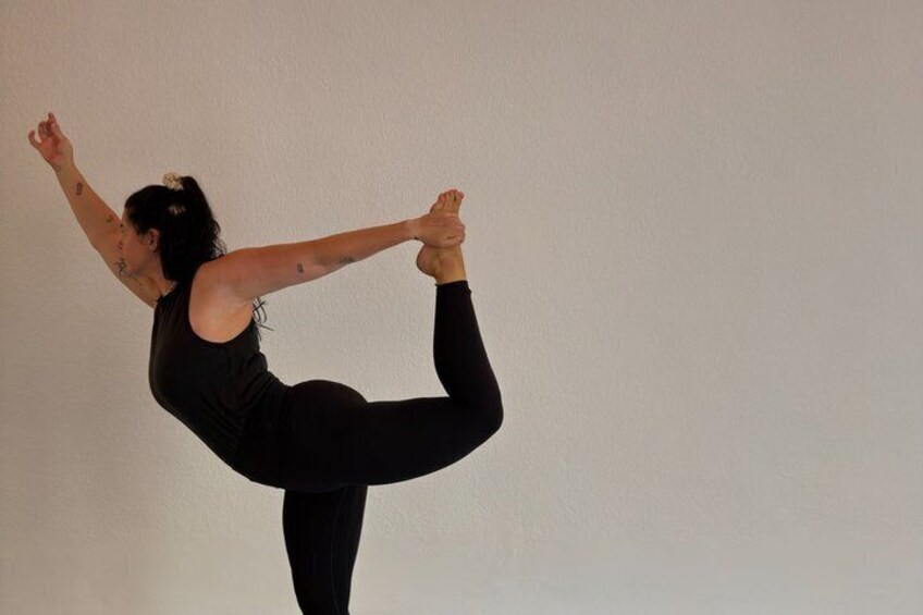 A person performing a yoga pose with one leg raised and arms extended. 4