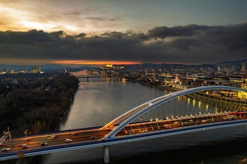 A river with a bridge, city skyline, and sunset. 2