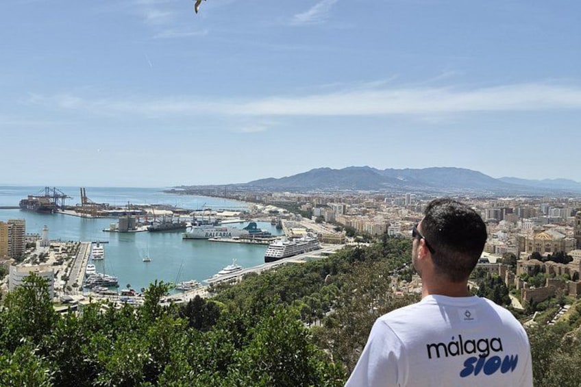 A coastal cityscape with a marina, buildings, and mountains in the background. 3