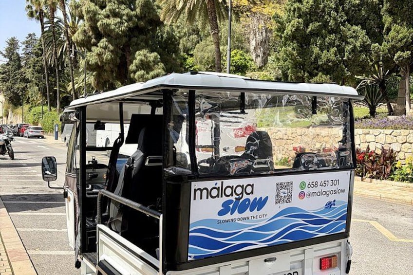 A vehicle with a blue and white advertisement for Malaga Slow. 4