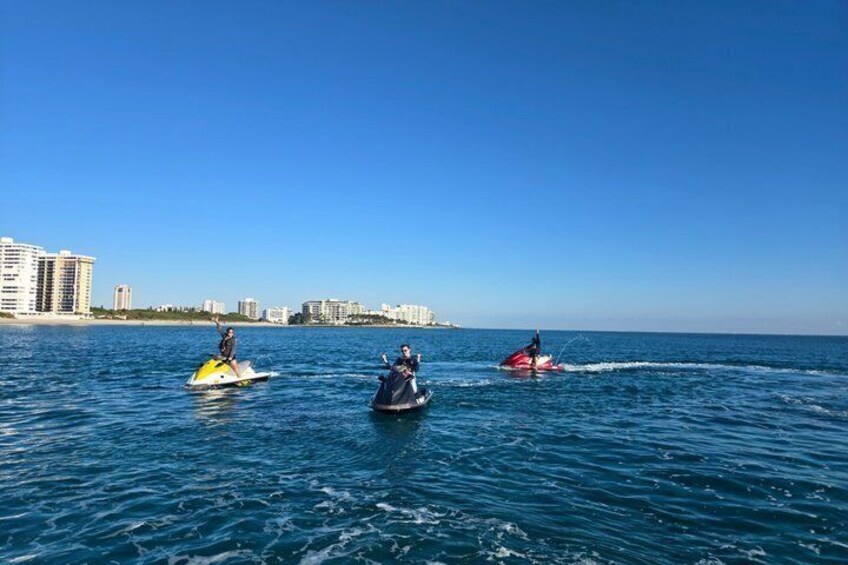 Three watercraft on a calm sea with buildings in the background. 3