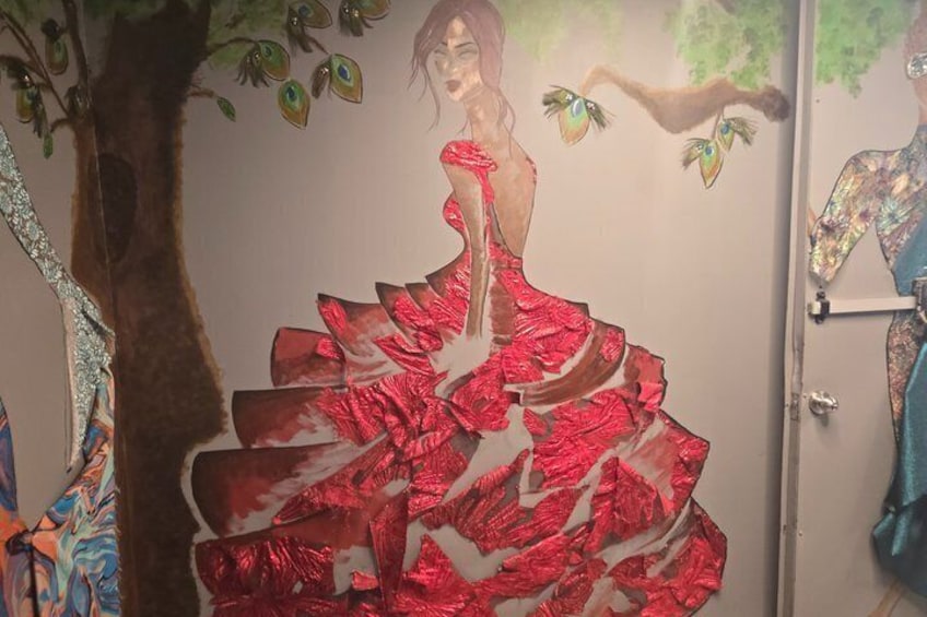 A mural of a woman in a red dress with a tree and birds. 3