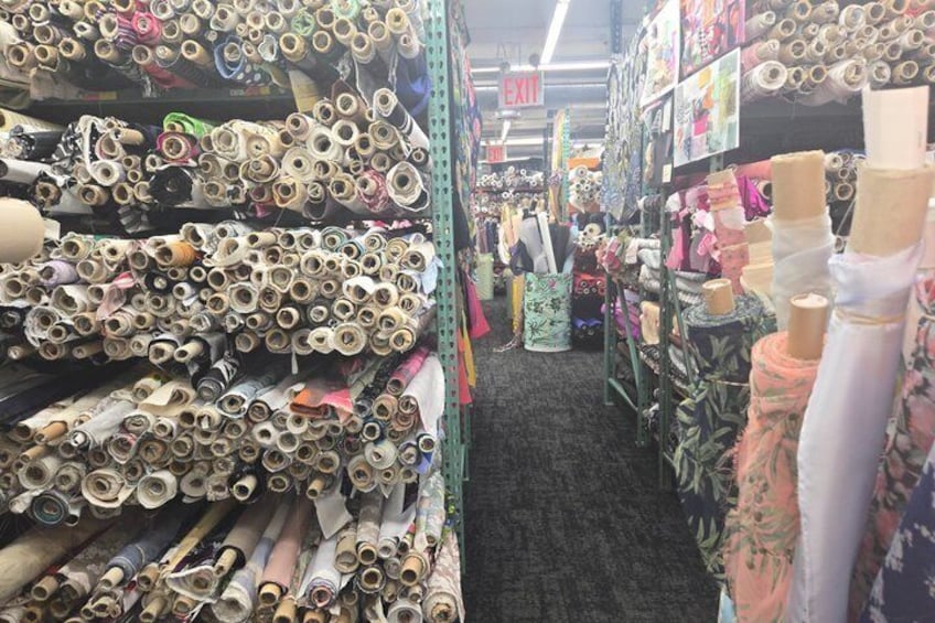 A fabric store with rolls of fabric on shelves. 2