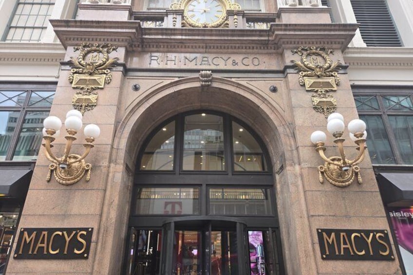 A building facade with 'RHIMACY & CO' and 'MACYS' signage, a large arched entrance, and decorative street lamps. 5
