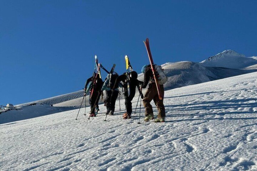 Skiers on a snowy slope with a mountain in the background. 5