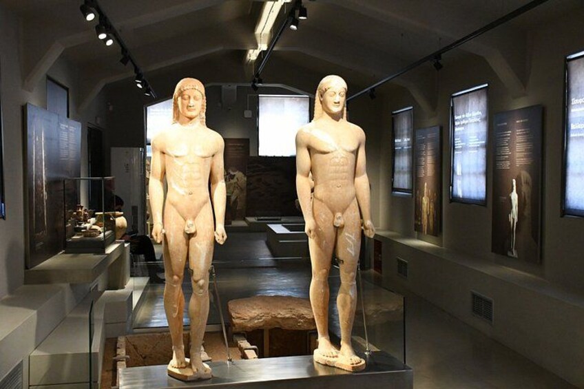 Two ancient human figures displayed in a museum setting. 5