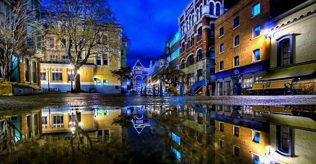 A nighttime cityscape with buildings reflected in a calm water body. 2