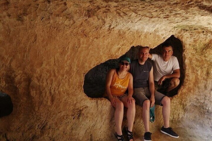 Three people sitting inside a cave. 2