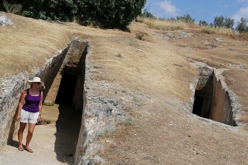 A person standing next to a man-made excavation with a narrow passageway. 4