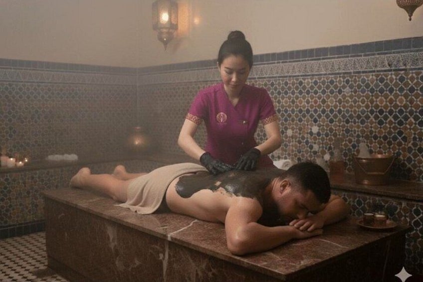 A person receiving a massage in a room with patterned tile walls and a traditional design. 4