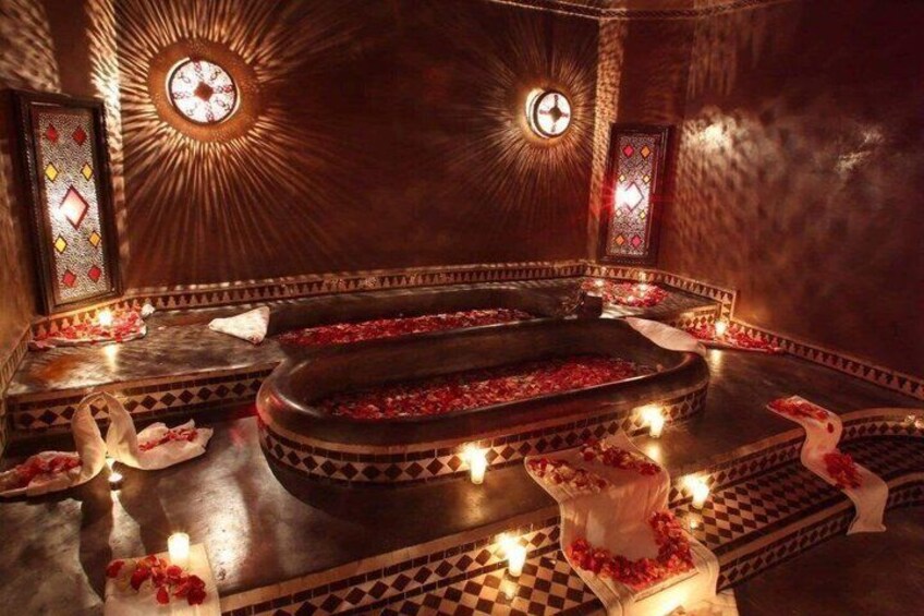 An ornate room with a central fountain, surrounded by patterned tiles and candlelit ambiance. 5
