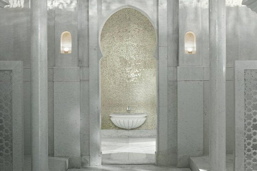 A stone archway leading to a white sink with a textured wall behind it. 1