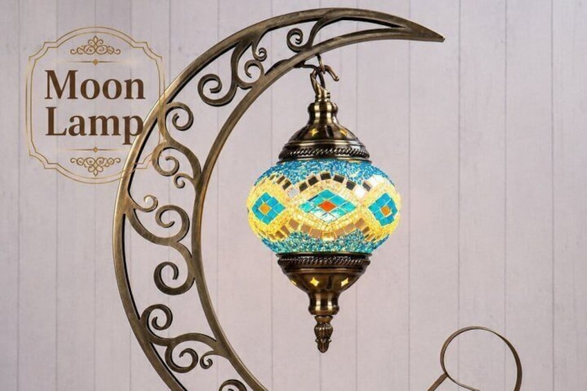 A decorative moon lamp with a mosaic pattern, mounted on a crescent-shaped metal stand. 5