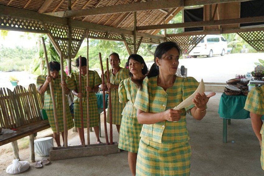 People in green and yellow checkered outfits, standing under a wooden structure with a fence. 3