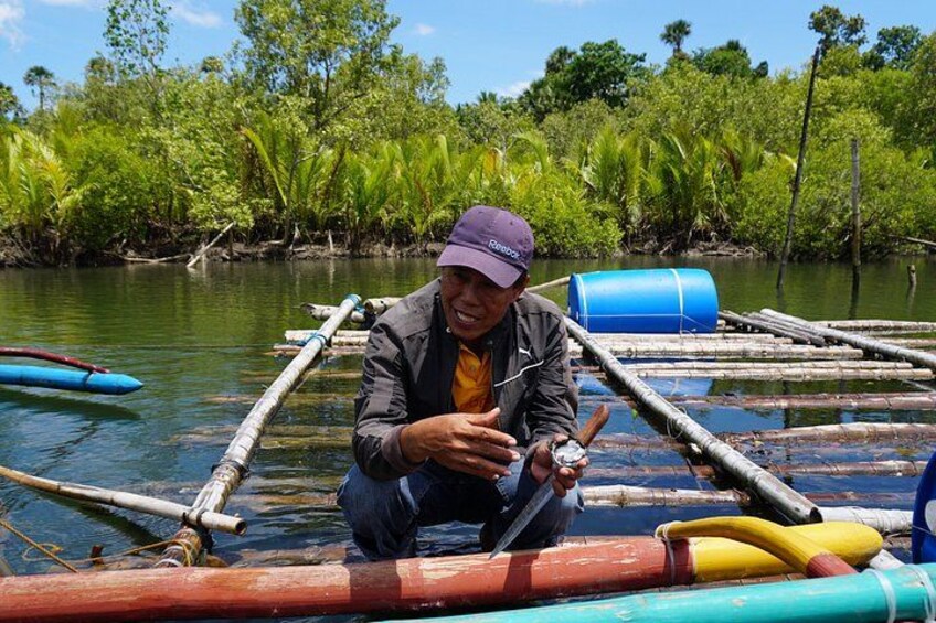 A person on a bamboo raft in a river surrounded by lush greenery. 1