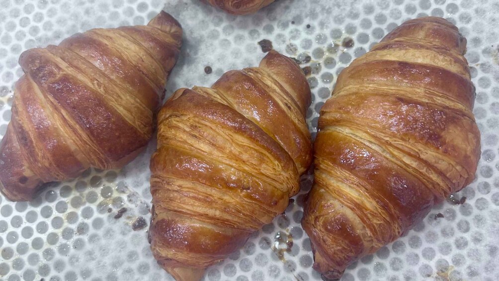 Three croissants on a baking sheet. 2