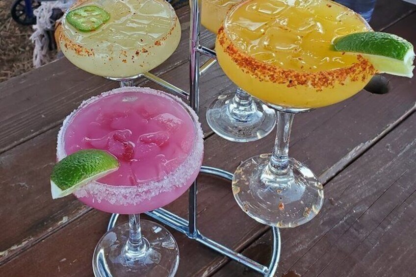 Three margaritas on a metal stand on a wooden table. 3