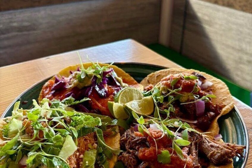A plate of tacos with various toppings and a lime wedge. 4