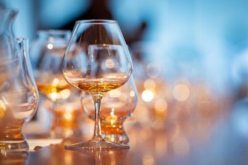 A glass of white wine on a table with blurred background lights. 1