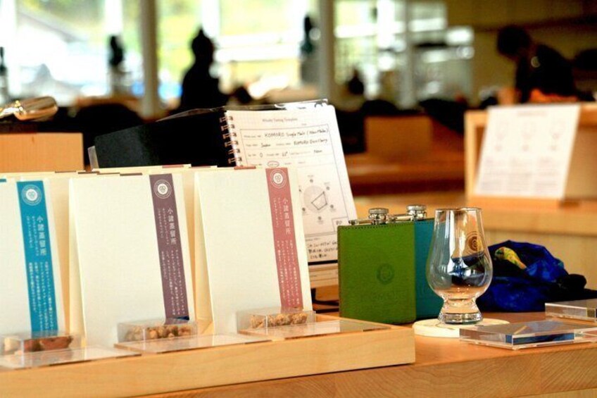 A book display with a glass of water and a notebook on a wooden table. 4