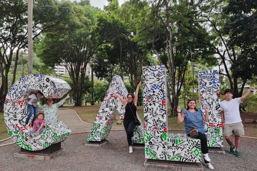 People posing with large letter-shaped sculptures covered in graffiti. 3