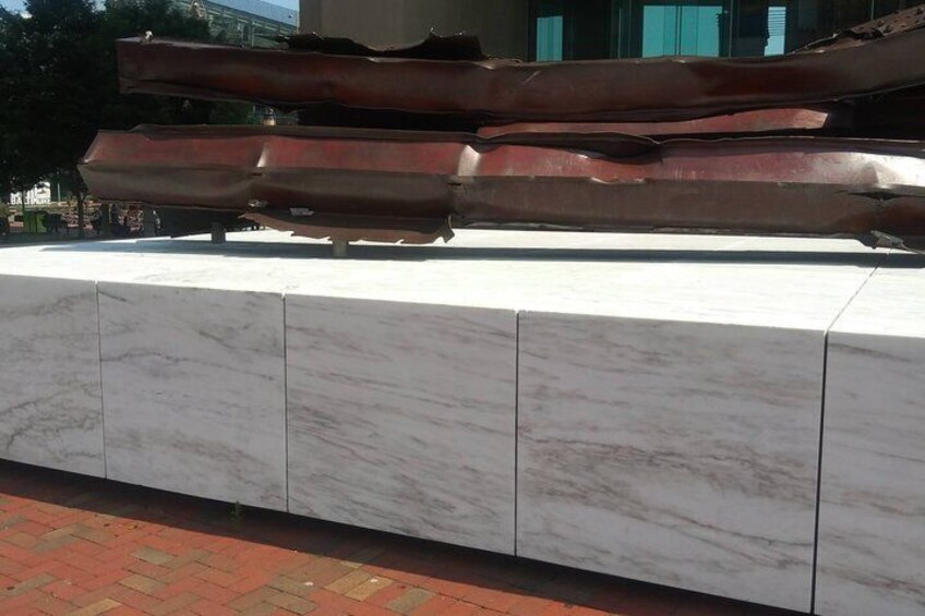 A metal sculpture on a white marble pedestal. 3