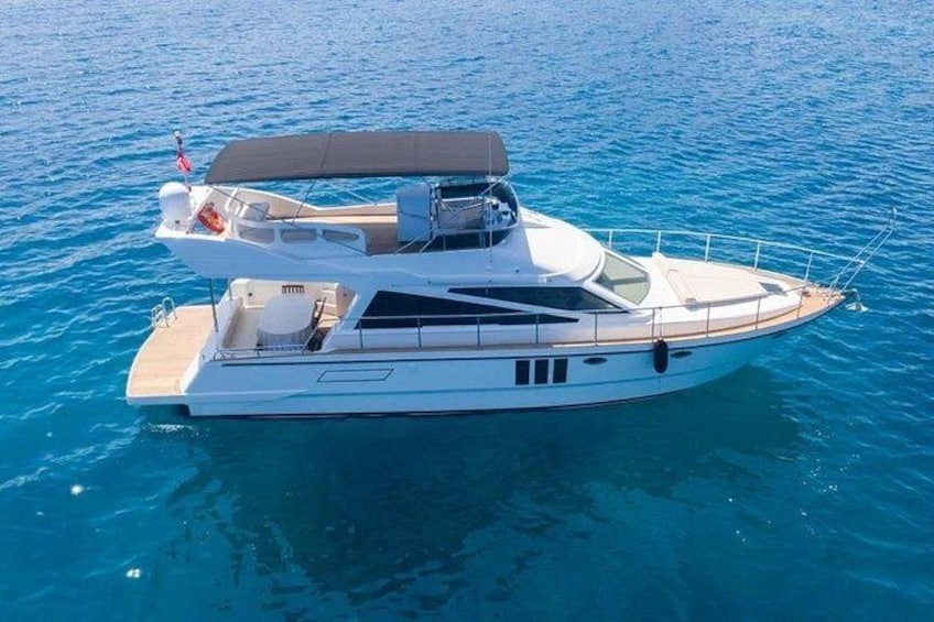 A white yacht with a covered deck, a cabin, and a small bridge. 3
