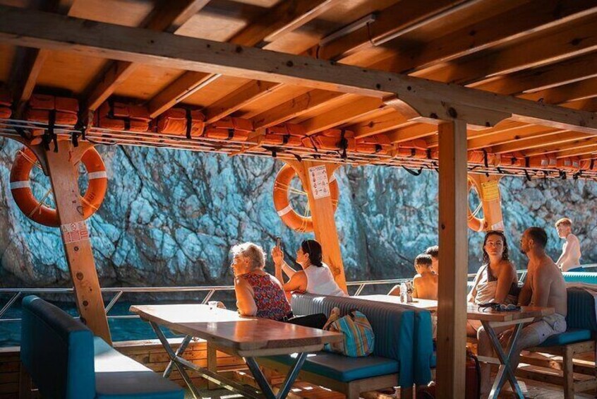 An outdoor dining area with tables and chairs, life rings, and a wooden ceiling. 4