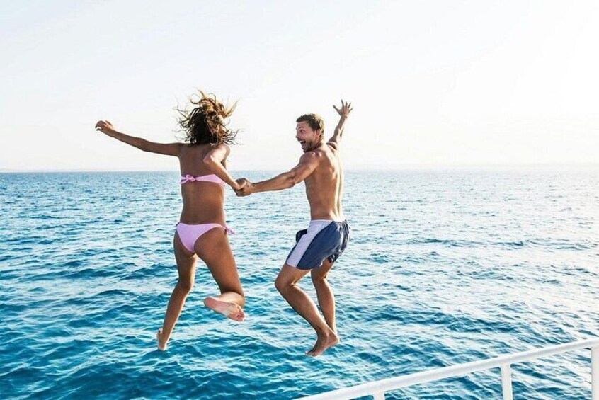 Two people jumping into the ocean from a dock. 5