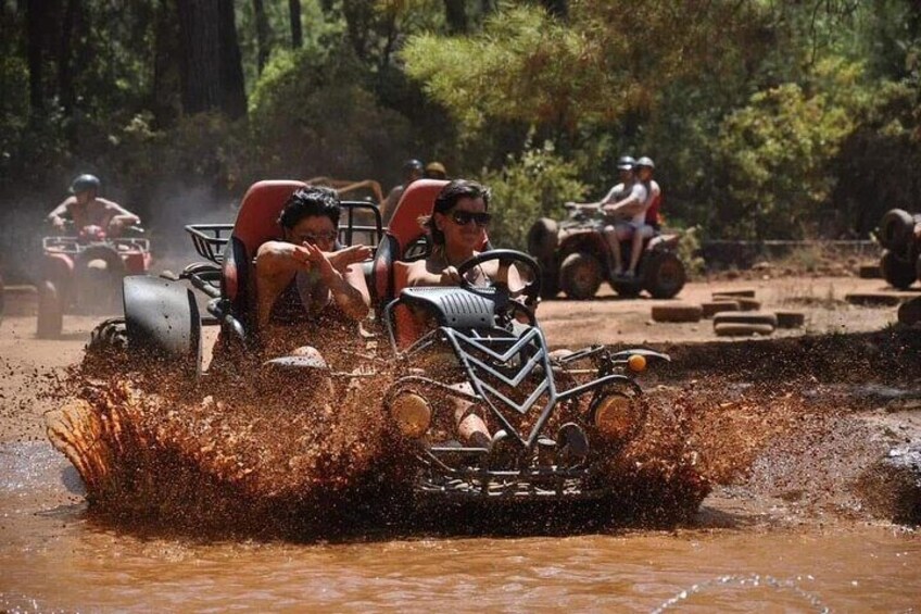 A quad bike navigating through a muddy water crossing. 5