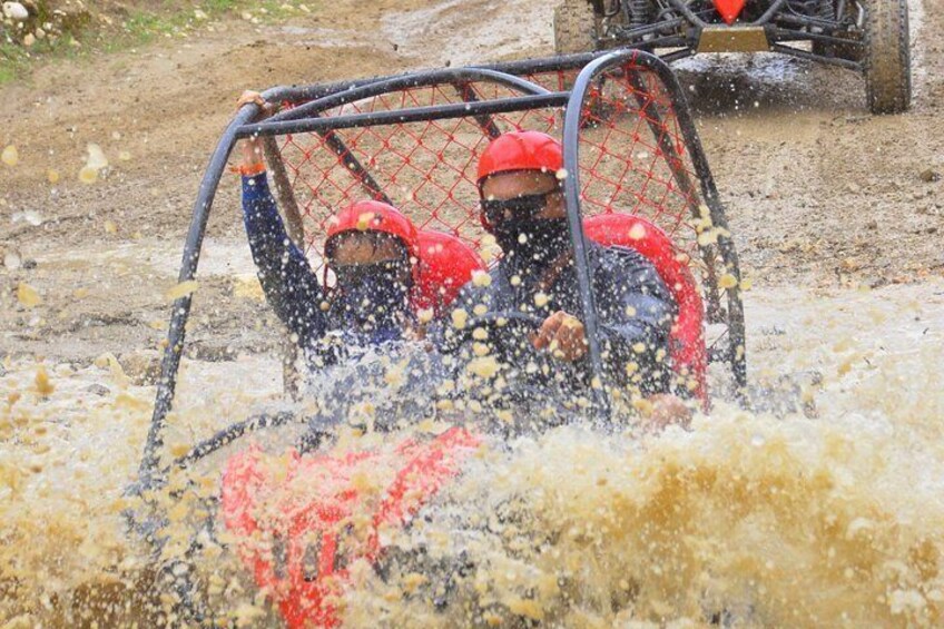 Two people in a cage-like structure being splashed by water. 4