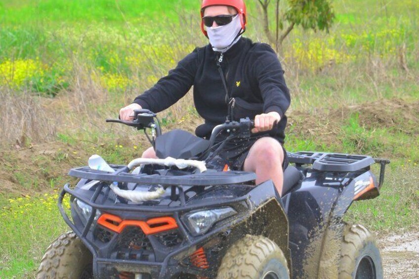 A person riding an ATV in a grassy field. 3