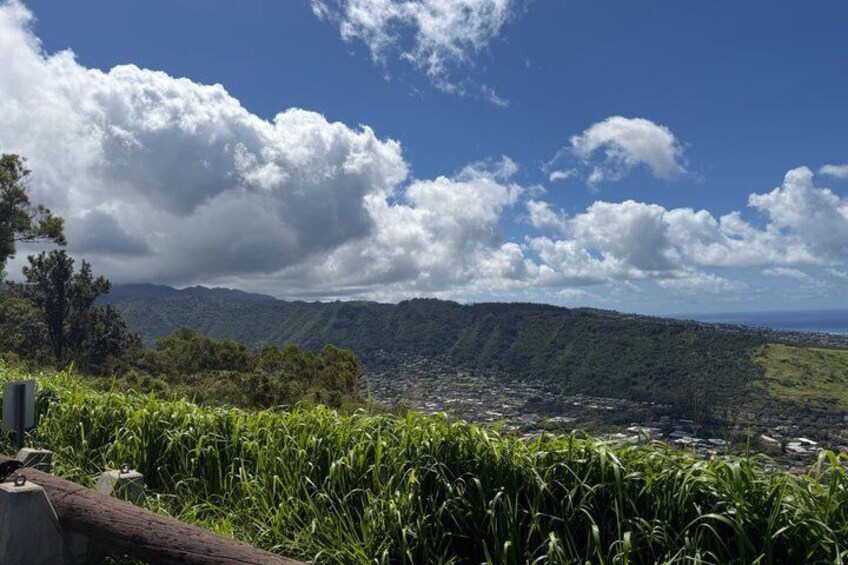 A mountainous landscape with a town in the valley, a clear sky, and lush greenery. 5