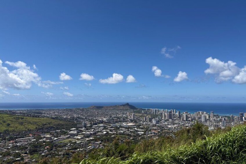 A coastal cityscape with a prominent mountain in the distance and a clear blue sky. 4