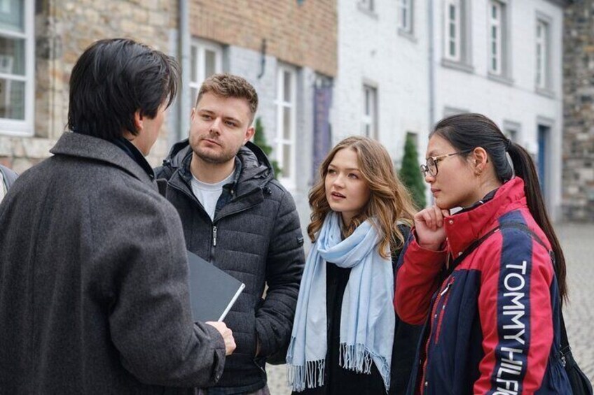 A group of people standing outdoors, engaged in conversation. 1