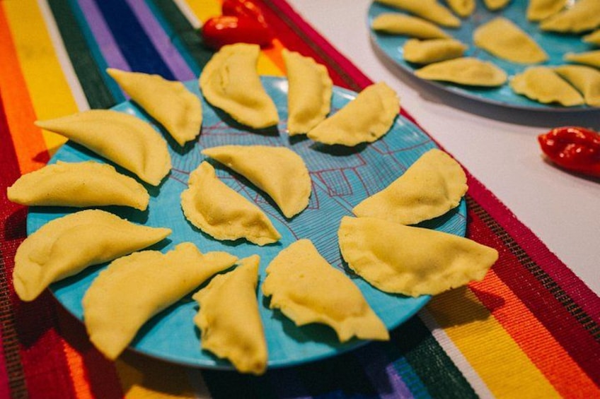 A plate of triangular-shaped food items on a colorful striped tablecloth. 3