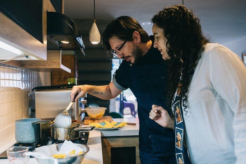 A person cooking in a modern kitchen with a stove, pots, and a cutting board. 2