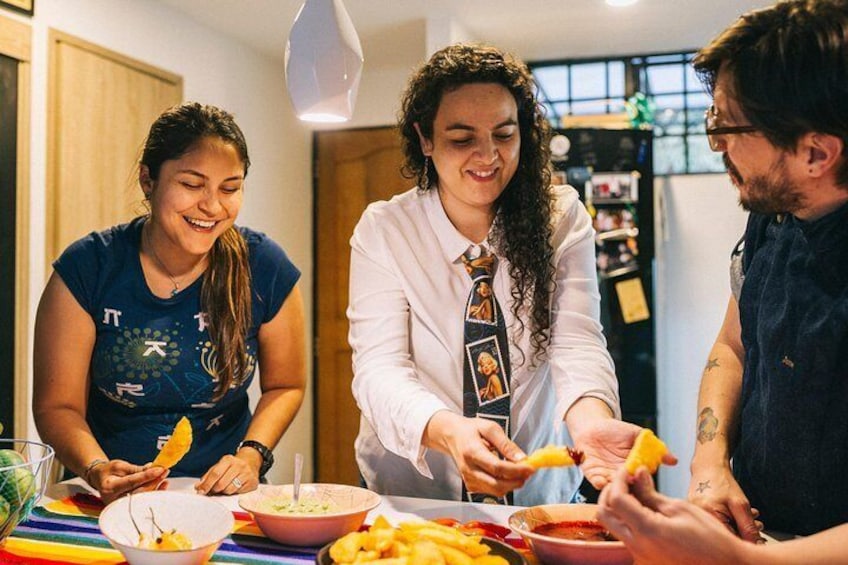 Three people preparing food at a table with bowls and plates. 2