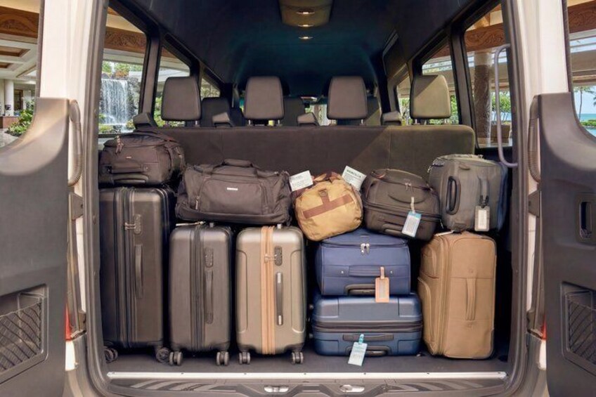 A vehicle's cargo area filled with various suitcases. 3