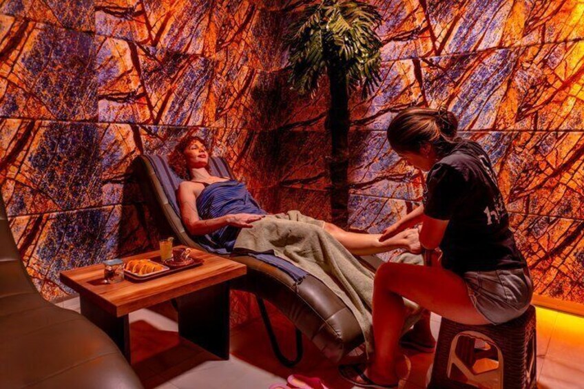 A person lying in a massage chair with a therapist attending to them. 5