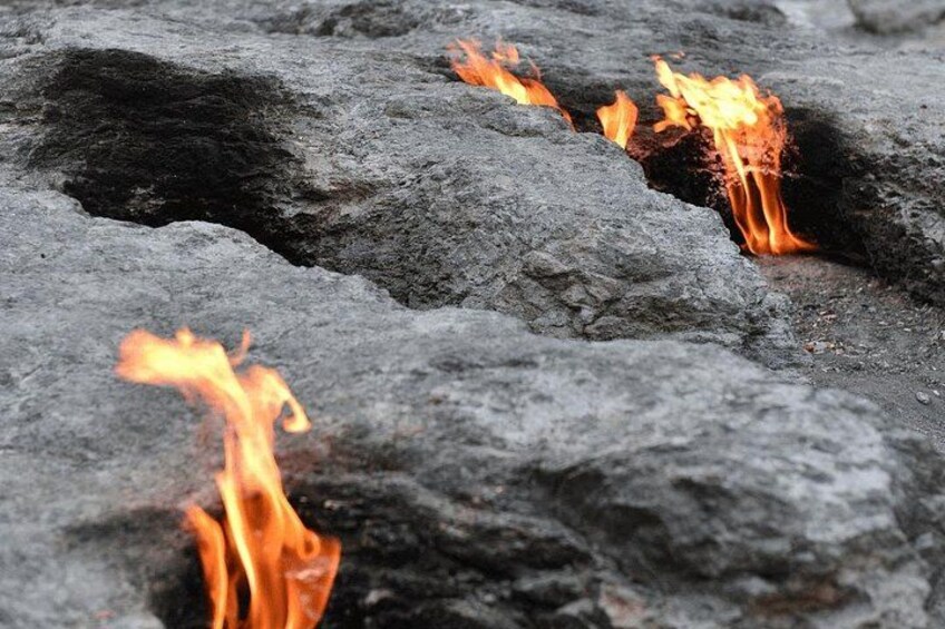 A close-up of burning charcoal with visible flames. 2