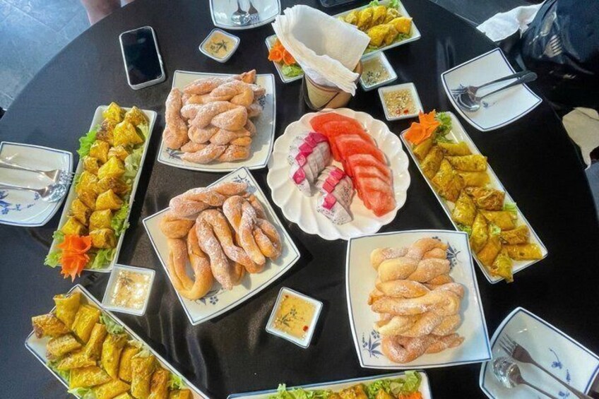 A table with various food items, including pastries and sliced meats, arranged for a gathering. 5